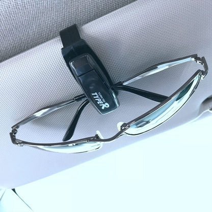 TYPER. Clip-soporte de automóvil para gafas de sol.