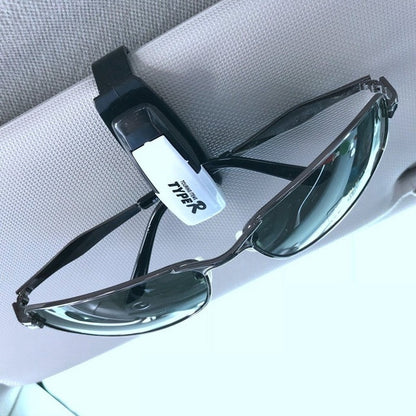 TYPER. Clip-soporte de automóvil para gafas de sol.